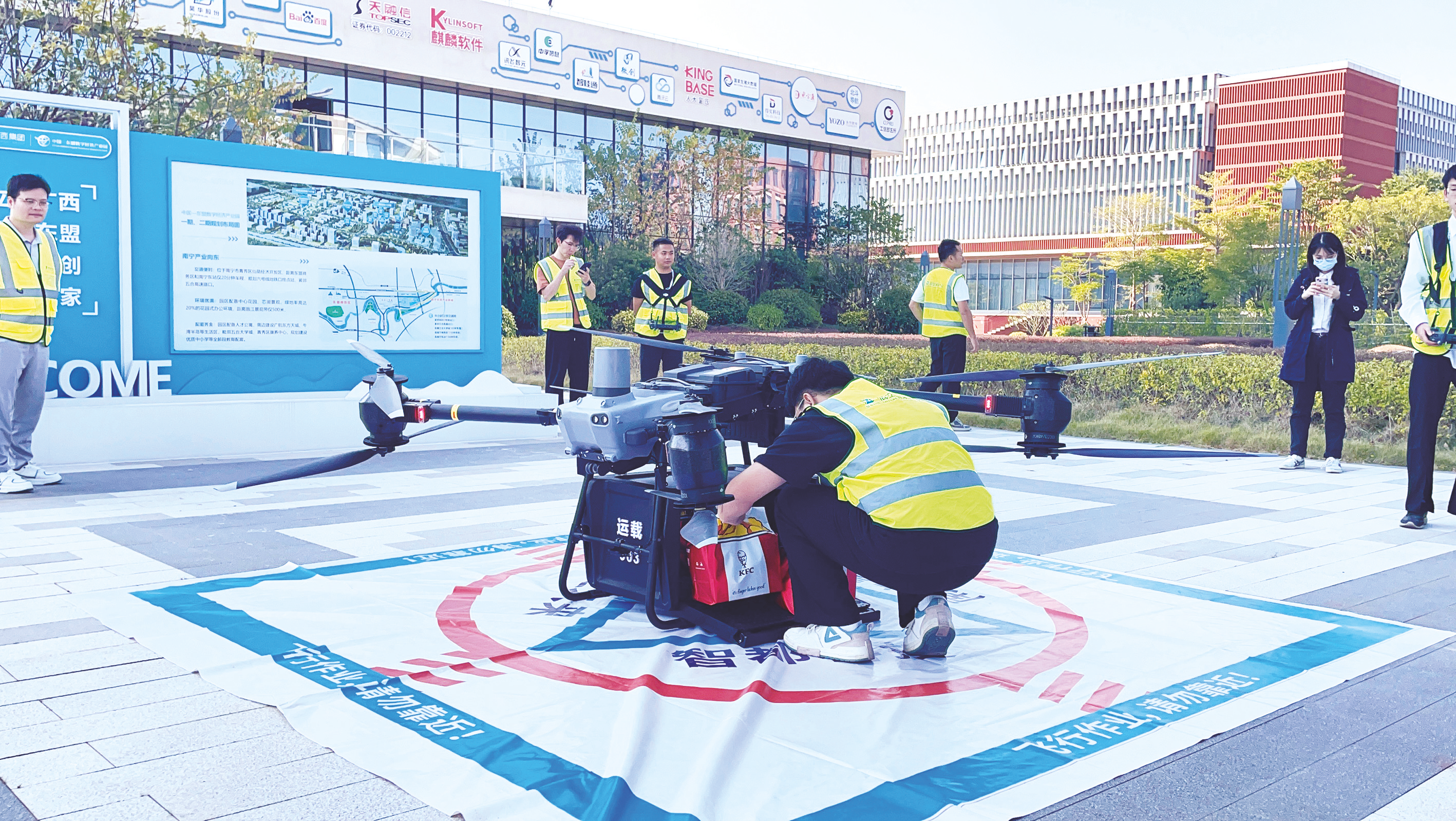 ????②南寧首單“低空外賣”成功送達配送點后,工作人員取貨。(韓樂聞 攝)